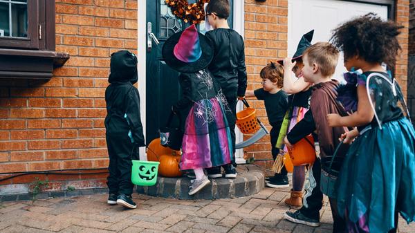 Dressed up children in front of a door on Hallowee