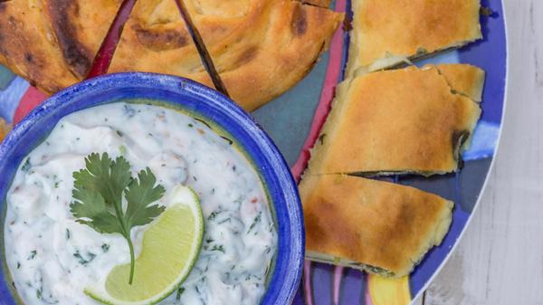 Griechischer Tzatziki-Dip und Gebäck auf einem bun
