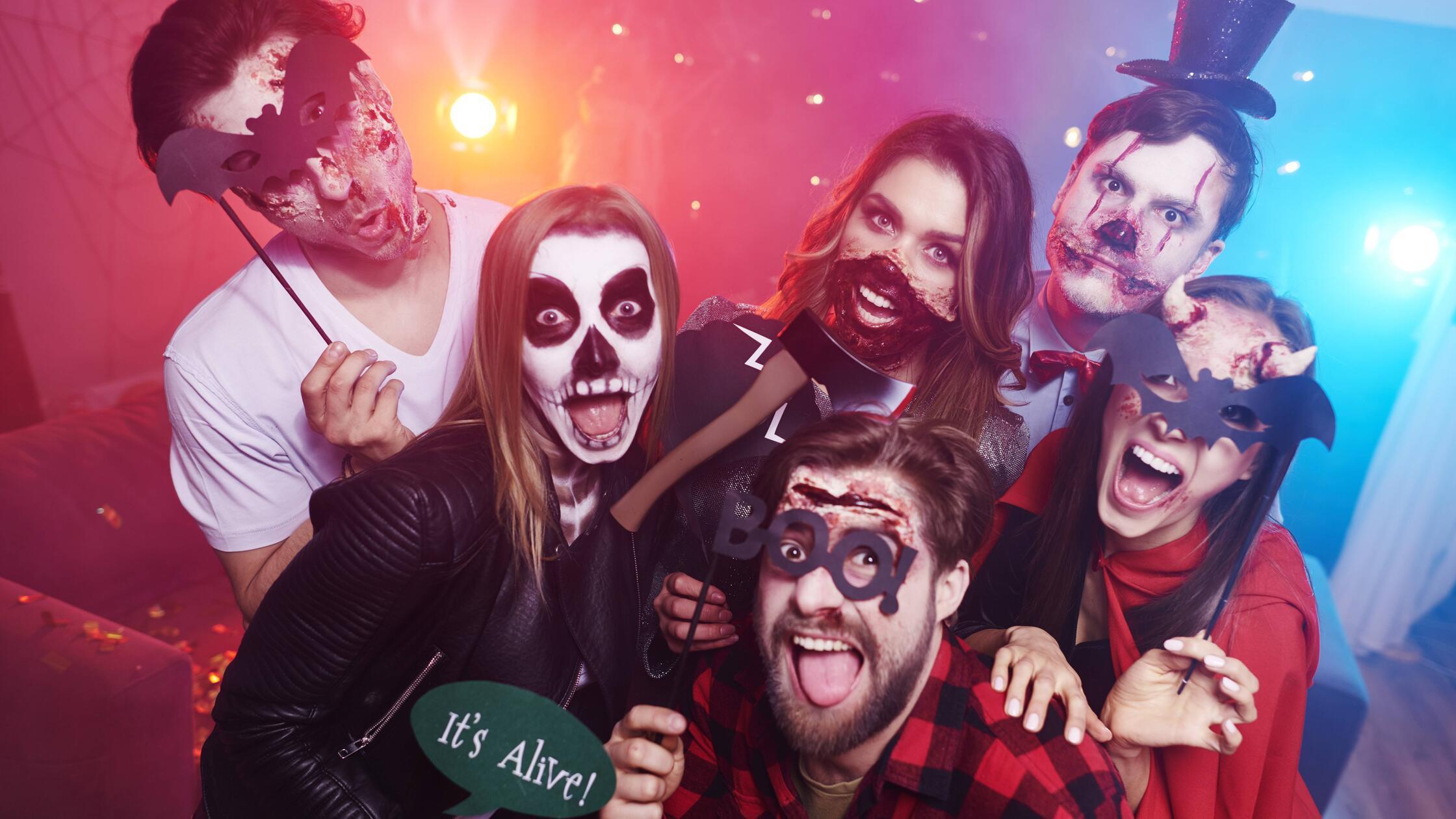 Friends in creepy costumes having fun at Halloween