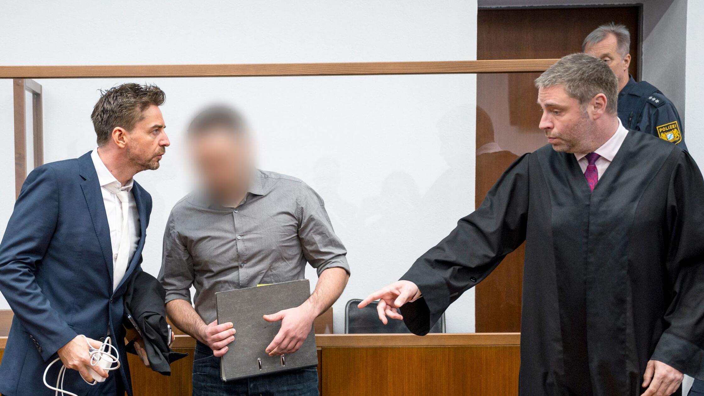 Der Angeklagte (M) betritt den Sitzungssaal. Seine