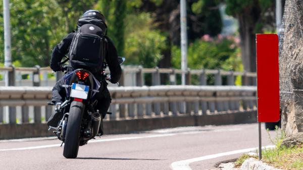 Ein Motorradfahrer fährt allein durch eine Kurve i