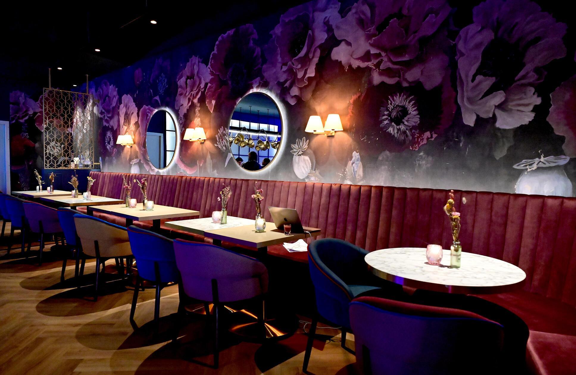 Typisch für das Ambiente der Gastro-Kette ist das verspielte und doch moderne Design: Viele Spiegel, viel Grün, goldene Elemente und Plüschsofas finden sich hier.