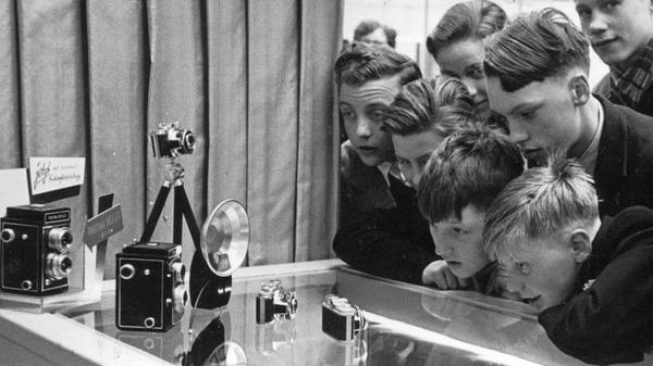 Wir schreiben das Jahr 1954 und befinden uns bei der vierten „Photo- und Kino-Ausstellung“, der „photokina“ in Köln. 176.000 Besucher wurden registriert, über 400 Firmen zeigten ihre neuen Entwicklungen. Interessenten, Aussteller und Importeure aus vielen Ländern fanden sich ein. Doch auch einige Nürnberger Firmen waren dabei. Auf unserem Bild bewundern einige Jungen verzückt die Photina Reflex-Kamera und die Photavit Kleinbildkamera aus den Bolta-Werken in Nürnberg. In ihre Gesichter, von denen es damals noch keine Selfies gab, steht die pure Begeisterung geschrieben.