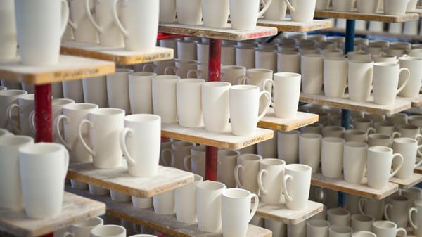 Ungebrannte Tassen stehen zur Trockunung in einem