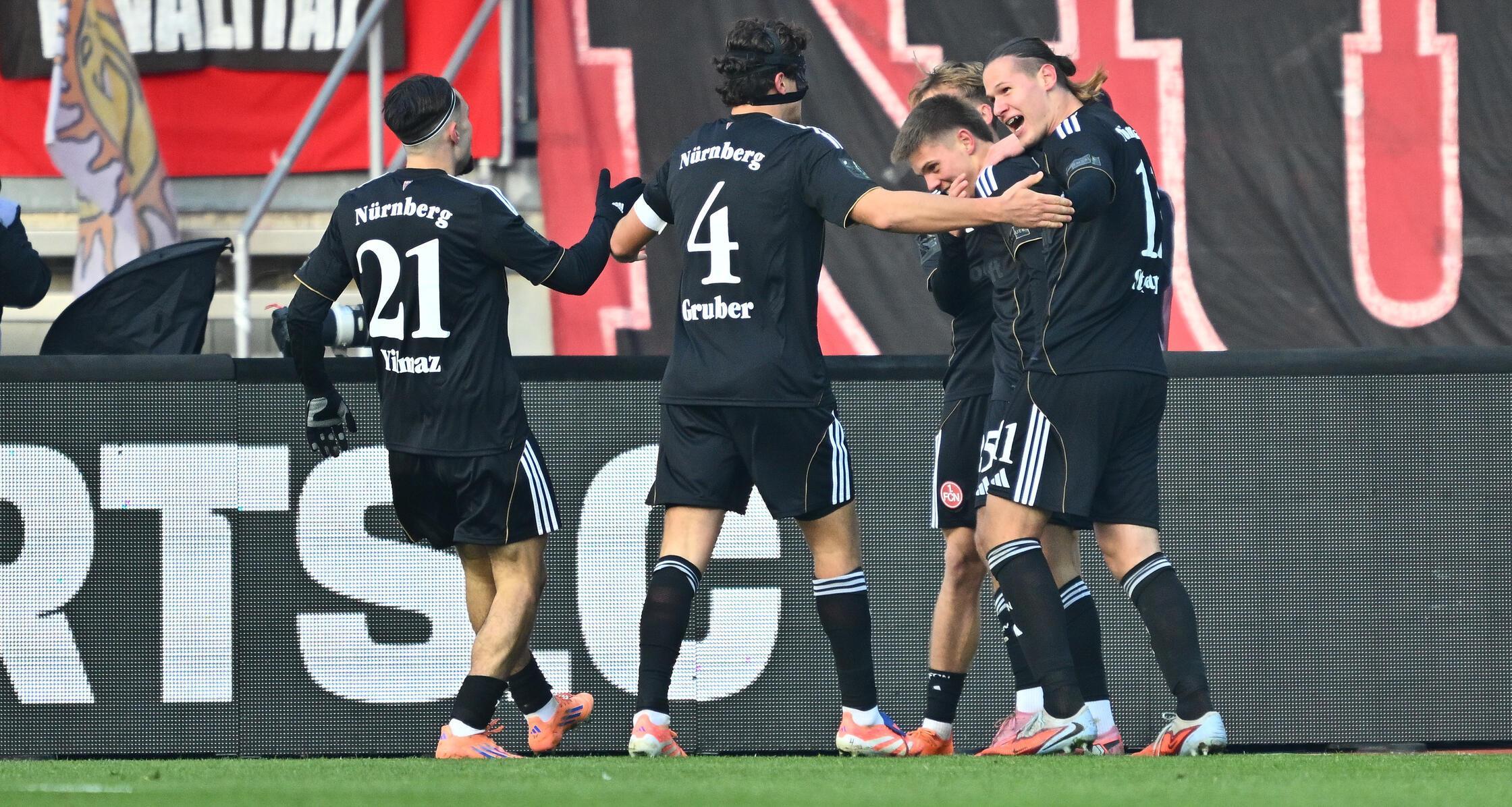 Seine Mitspieler freuen sich mit dem Torschützen, alles sieht nach einem ungefährdeten Heimsieg für den FCN aus.