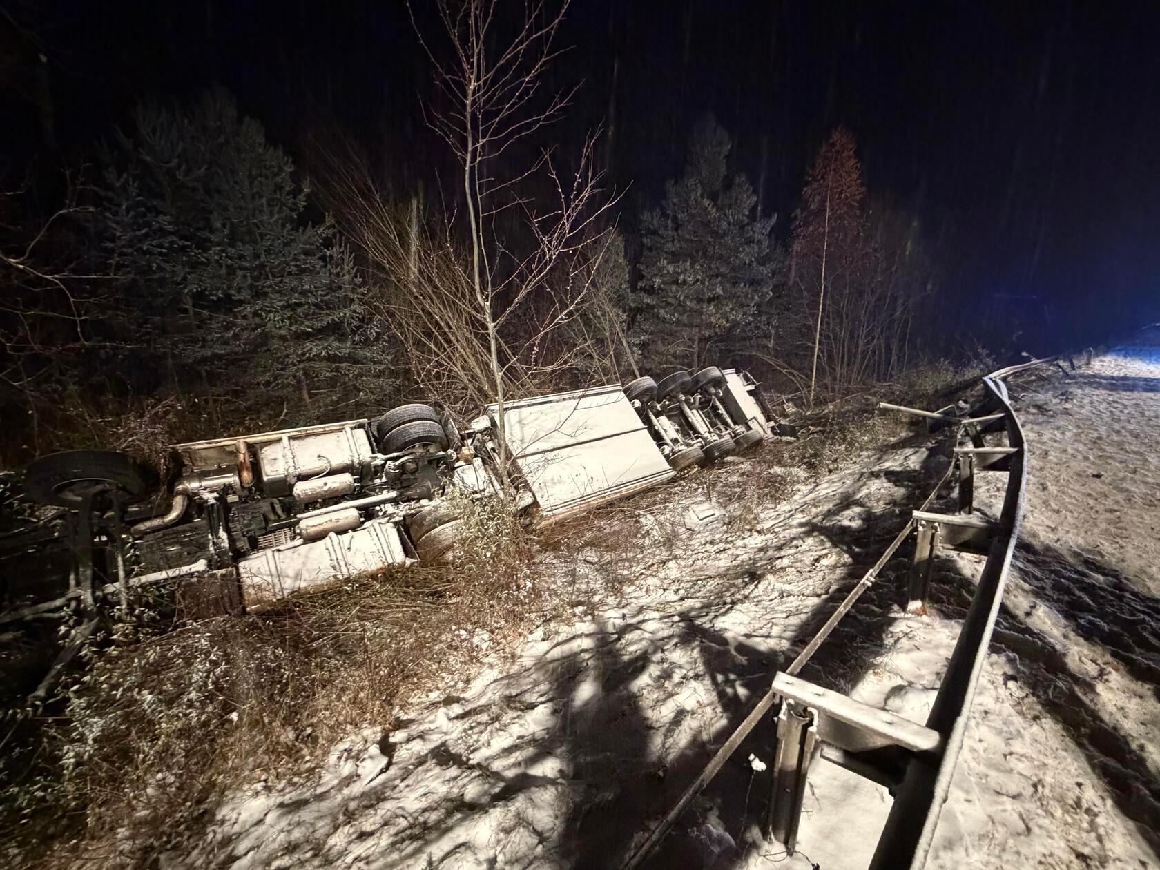 Nach ersten Informationen rutschte der Lkw auf glatter Fahrbahn nach rechts weg, kippte in den Graben und blieb in einer Böschung auf dem Dach liegen.
