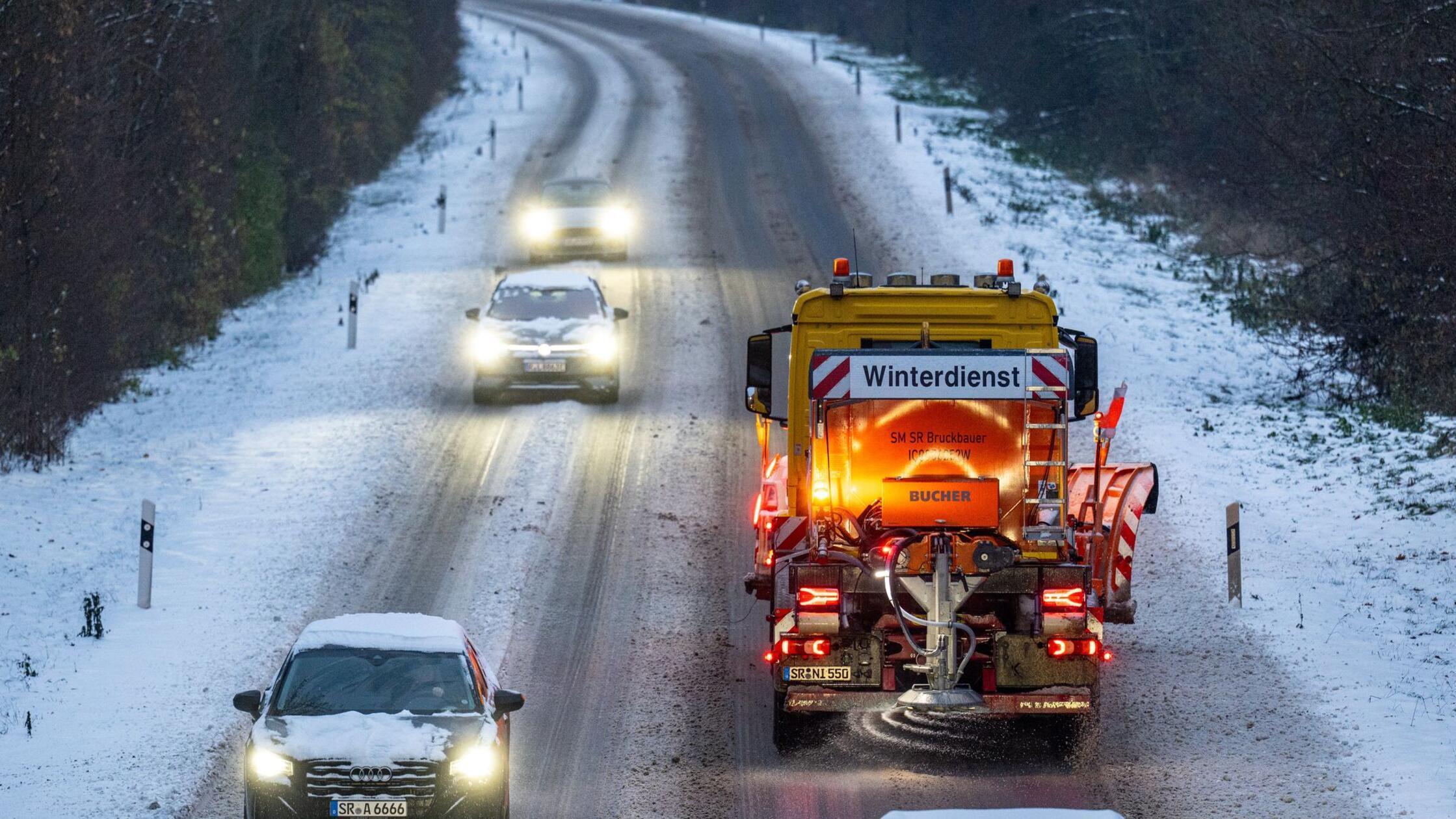 Ein Fahrzeug vom Winterdienst fährt auf der mit Sc