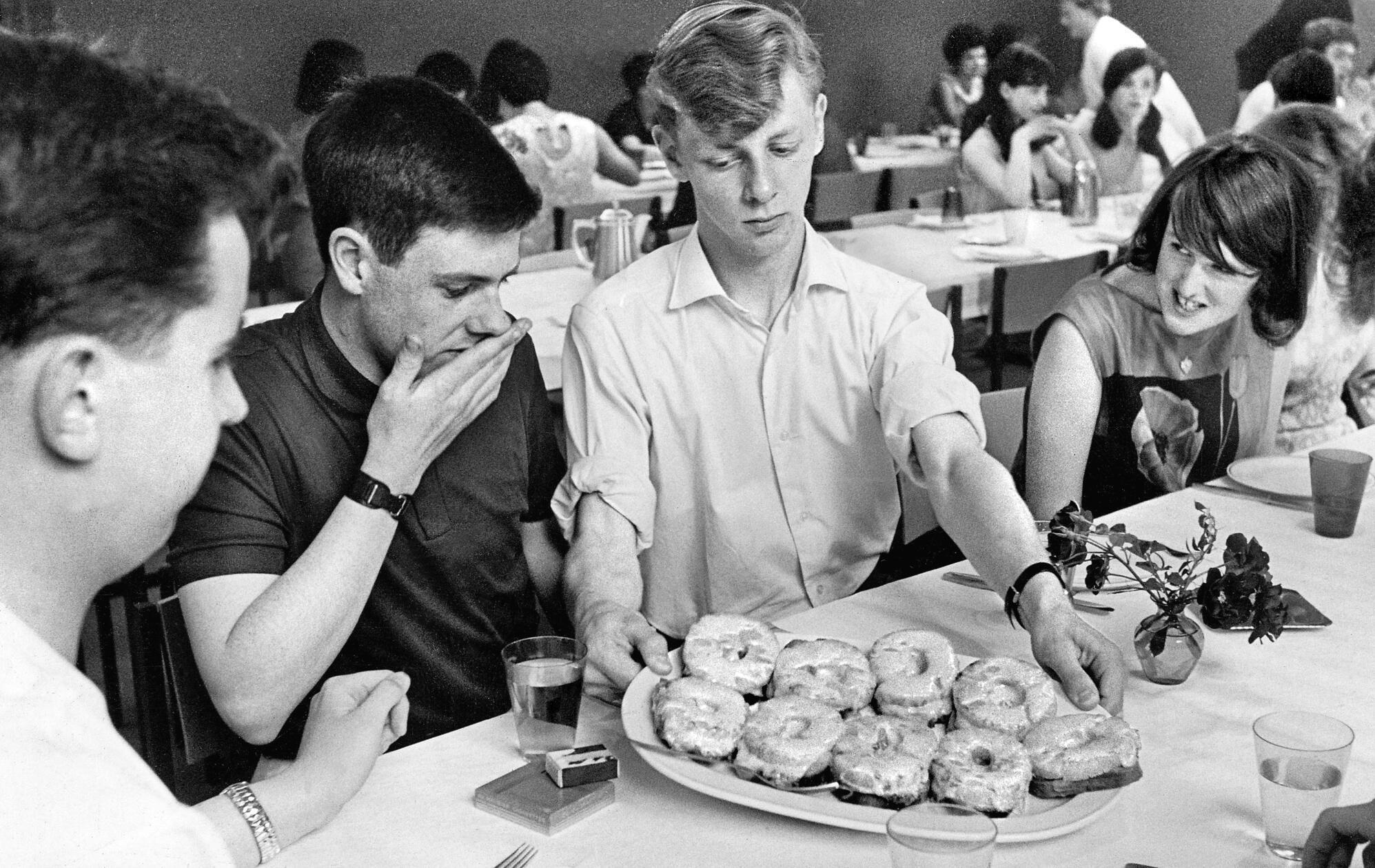 Zu Tisch bitte, hieß es für 56 Austauschschülerinnen und -schüler aus Glasgow und Nizza, die im August 1965 zu Gast in Nürnberg waren. Auf ovalen Platten wurden Schinken und Ananas, mit Käse überbacken, auf Toast serviert, den die „Jung-Europäer mehr begehrten, als Eisbein, Kraut und Kniedla“, wie es seinerzeit in unserer Berichterstattung hieß. Für die hier abgebildeten jungen Menschen schien der Anblick von Toast Hawaii jedoch eher ein kulinarischer Schreckmoment gewesen zu sein.