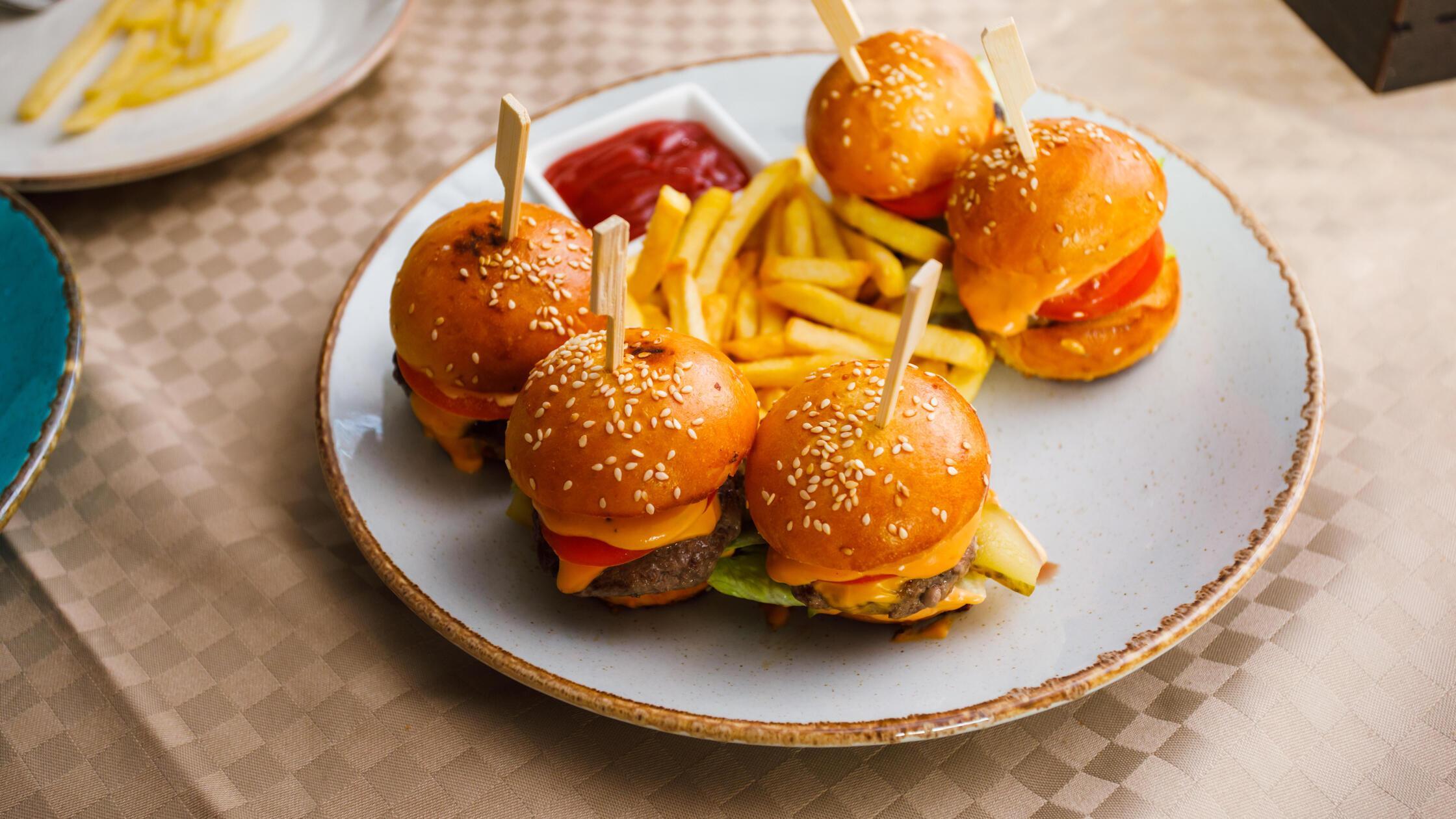 Mini burgers and fried potatoes on the plate