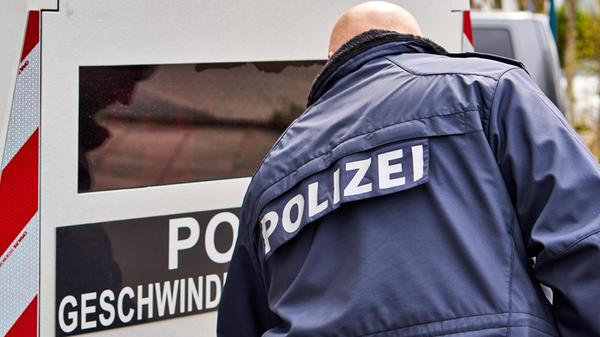 Ein Polizist in Uniform steht vor einem mobilen Bl