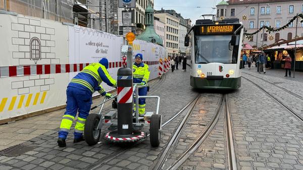 Ein Handwagen rollt heran, zwei Sicherheitskräfte