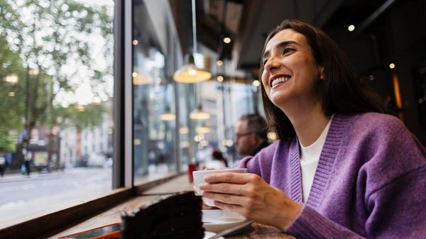 Smiling woman enjoying coffee and chocolate cake a