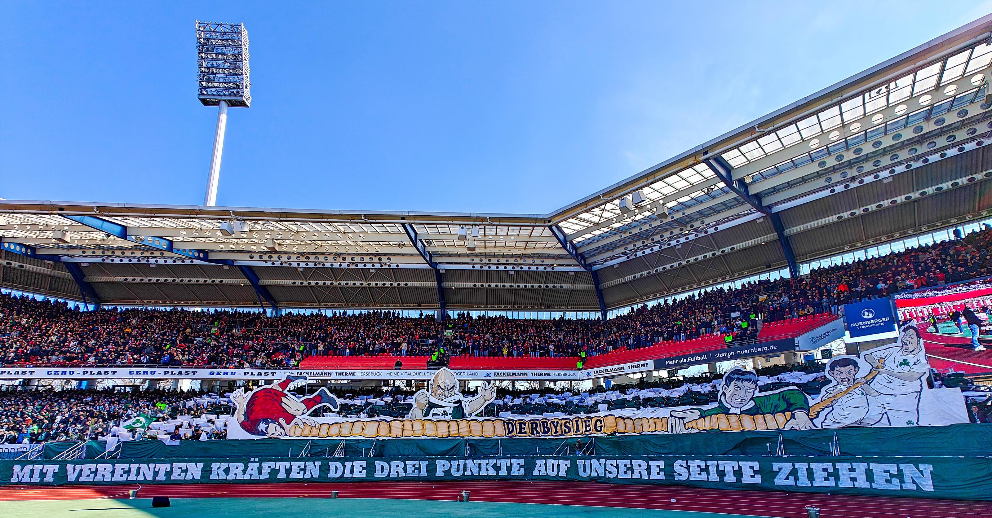 Im Gästeblock vergleichen die Anhänger der SpVgg Greuther Fürth das Frankenderby mit einem Tauziehen - an der einen Seite die siegreichen Fürther, auf der anderen Seite die am Boden liegenden Feinde von der anderen Seite der Stadtgrenze. Ihrer Forderung "Mit vereinten Kräften die drei Punkte auf unsere Seite ziehen" kommt die Mannschaft allerdings nicht nach: Mit 0:3 unterliegt das Kleeblatt im Max-Morlock-Stadion.