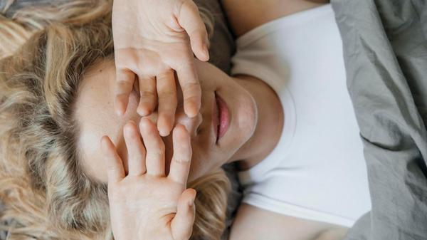 Blond woman covering eyes with hands