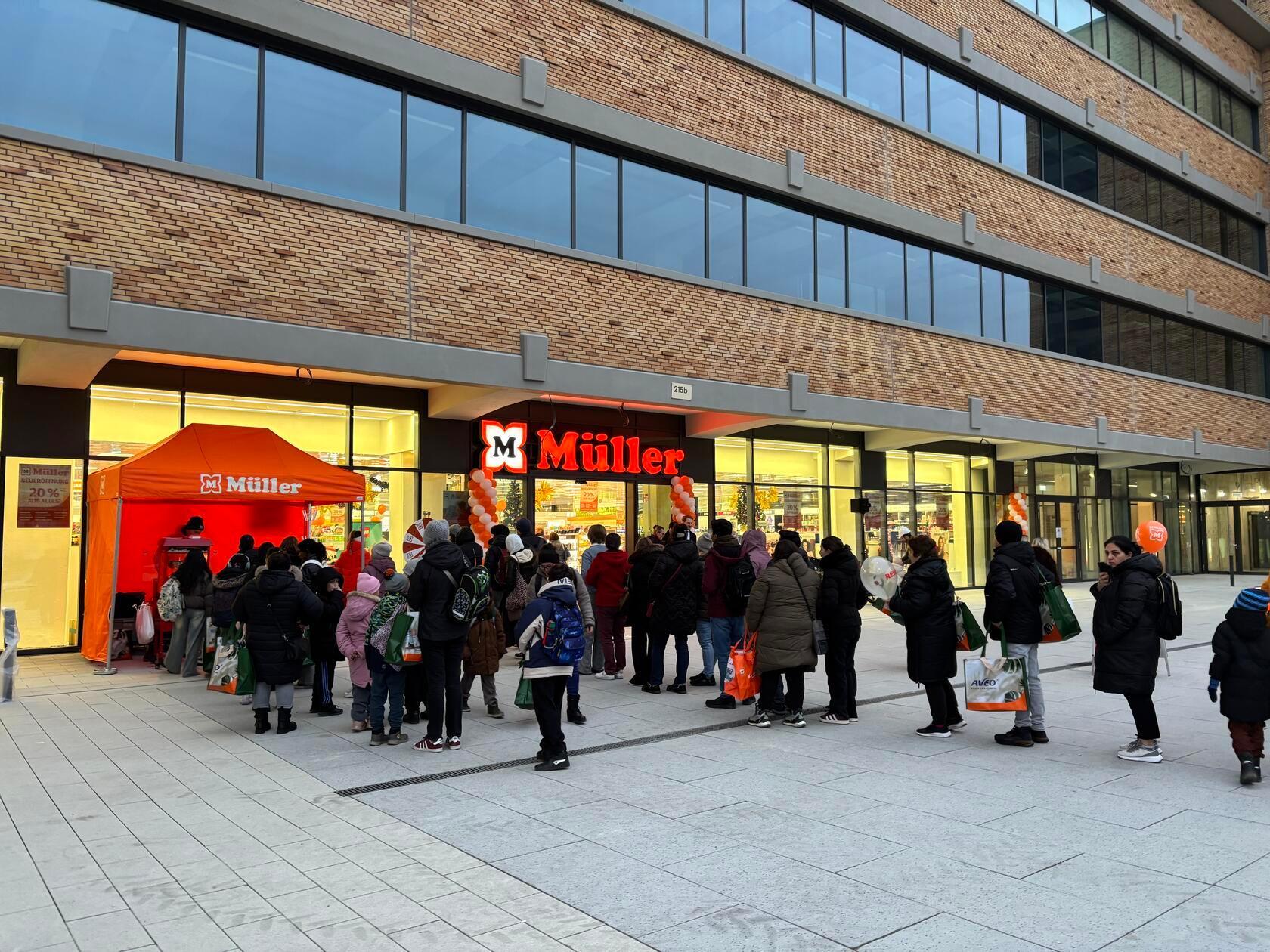 Vor der neuen Filiale der Drogeriekette Müller stehen einige Menschen Schlange.