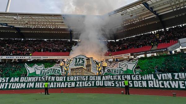 Der Kleeblatt-Anhang nutzte schon die Choreografie vor Spielbeginn zum Zünden von Pyrotechnik - eine Fackel erhellt das Fürther Rathaus in Banner-Form.