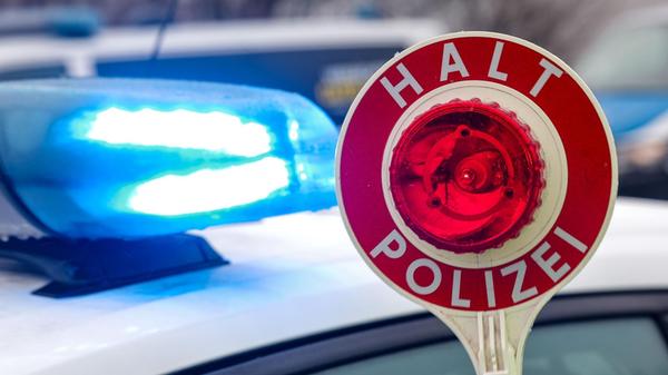 Ein Polizist hält eine Polizeikelle für eine Kontr
