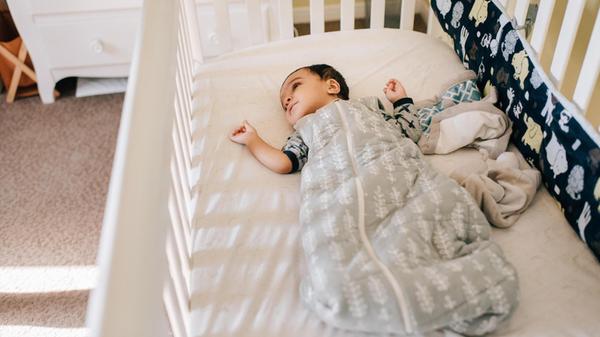 Baby boy lying awake in crib, high angle view