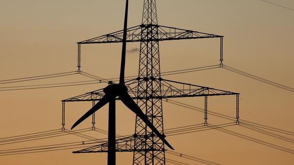 Ein Windrad steht bei Sonnenuntergang vor einem St