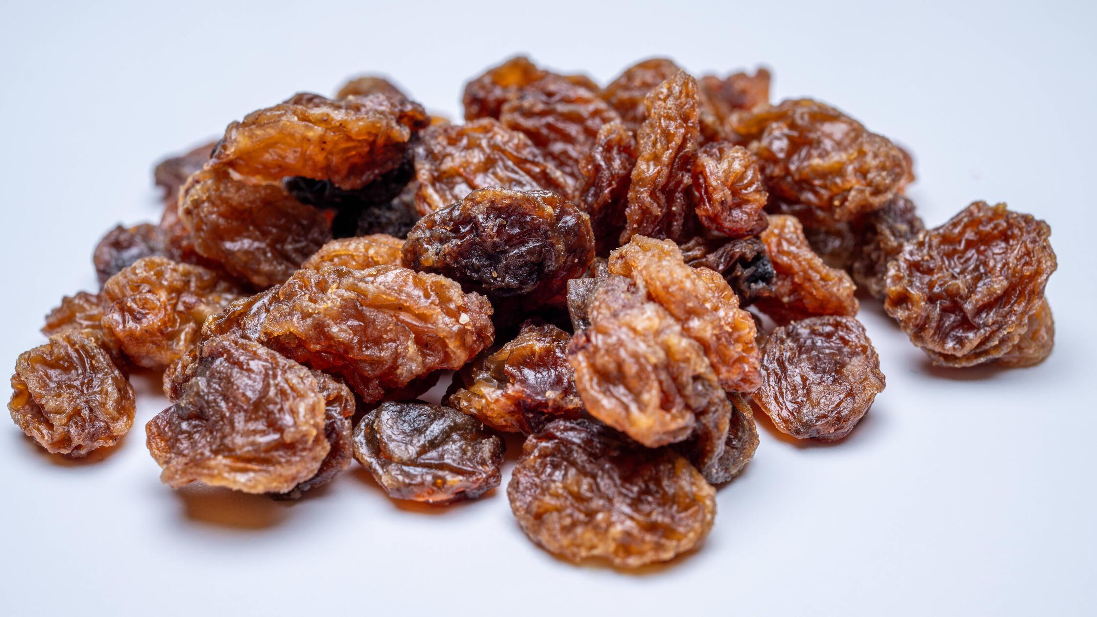 Nahaufnahme von Rosinen auf Weiß , Deutschland, 09