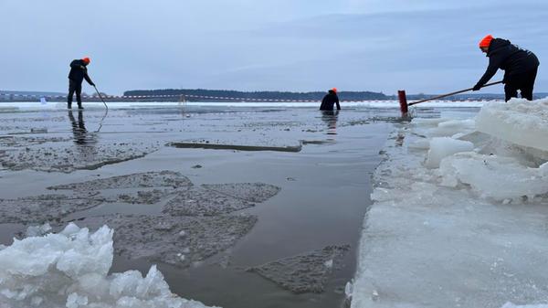 Damit am nächsten Tag überhaupt gebadet werden kann, rücken Helfer mit Kettensägen an. Die Eisdecke wird aufgeschnitten, ein großes Rechteck freigelegt.