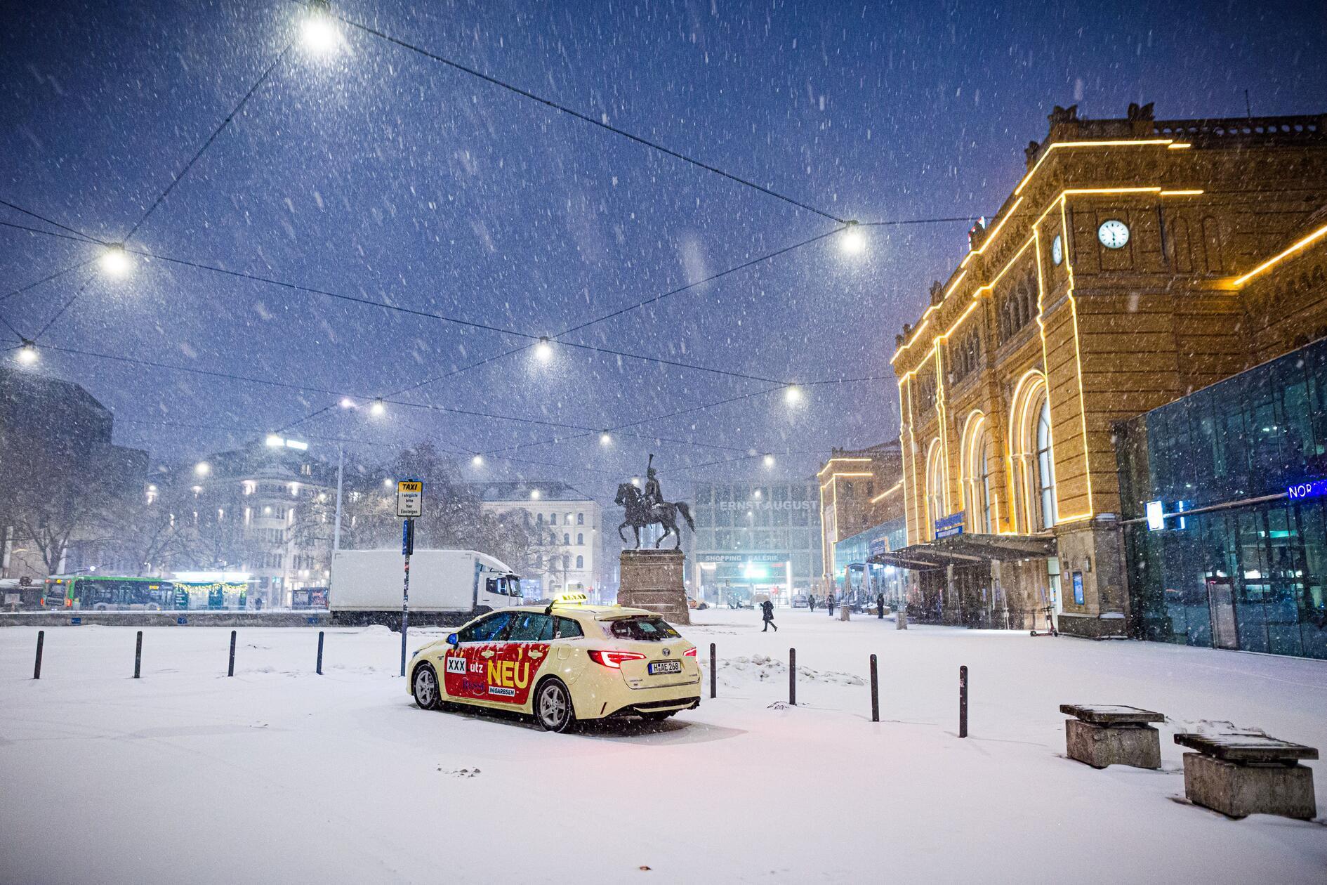 Ein Taxi parkte in Hannover am frühen Morgen im dichten Schneefall auf dem Ernst-August-Platz vor dem Hauptbahnhof.