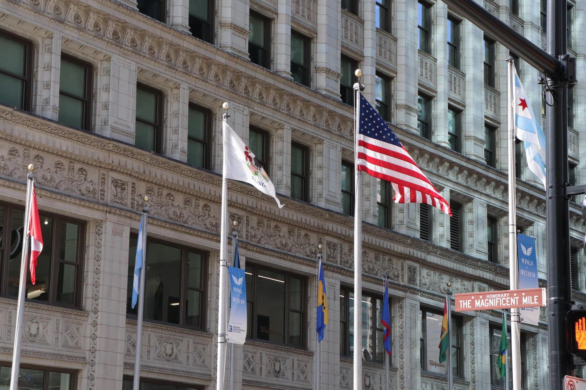 Rechts im Bild die Flagge Chicagos. Die zwei blauen Streifen stehen hierbei für den Chicago River und den Michigansee, die weißen Anteile für die Seiten der Stadt und die roten Sterne für einschneidende Geschehnisse in der Stadtgeschichte.