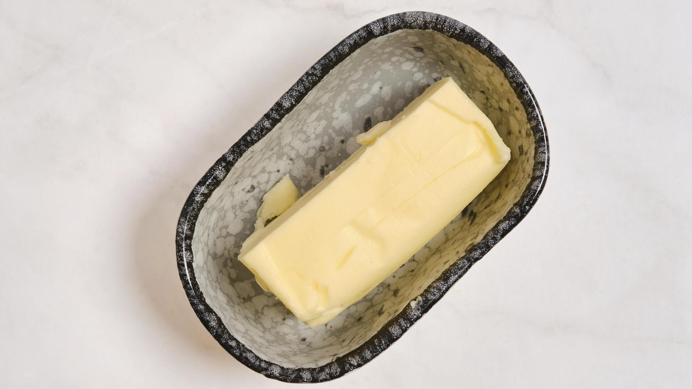 Ein Stück Butter in einer grauen Schale auf einer 