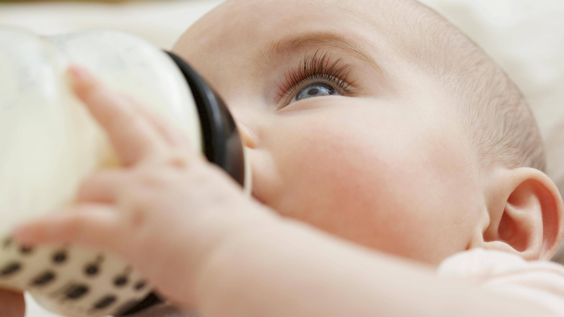 Close up of Baby Girl Drinking from Baby Bottle PU