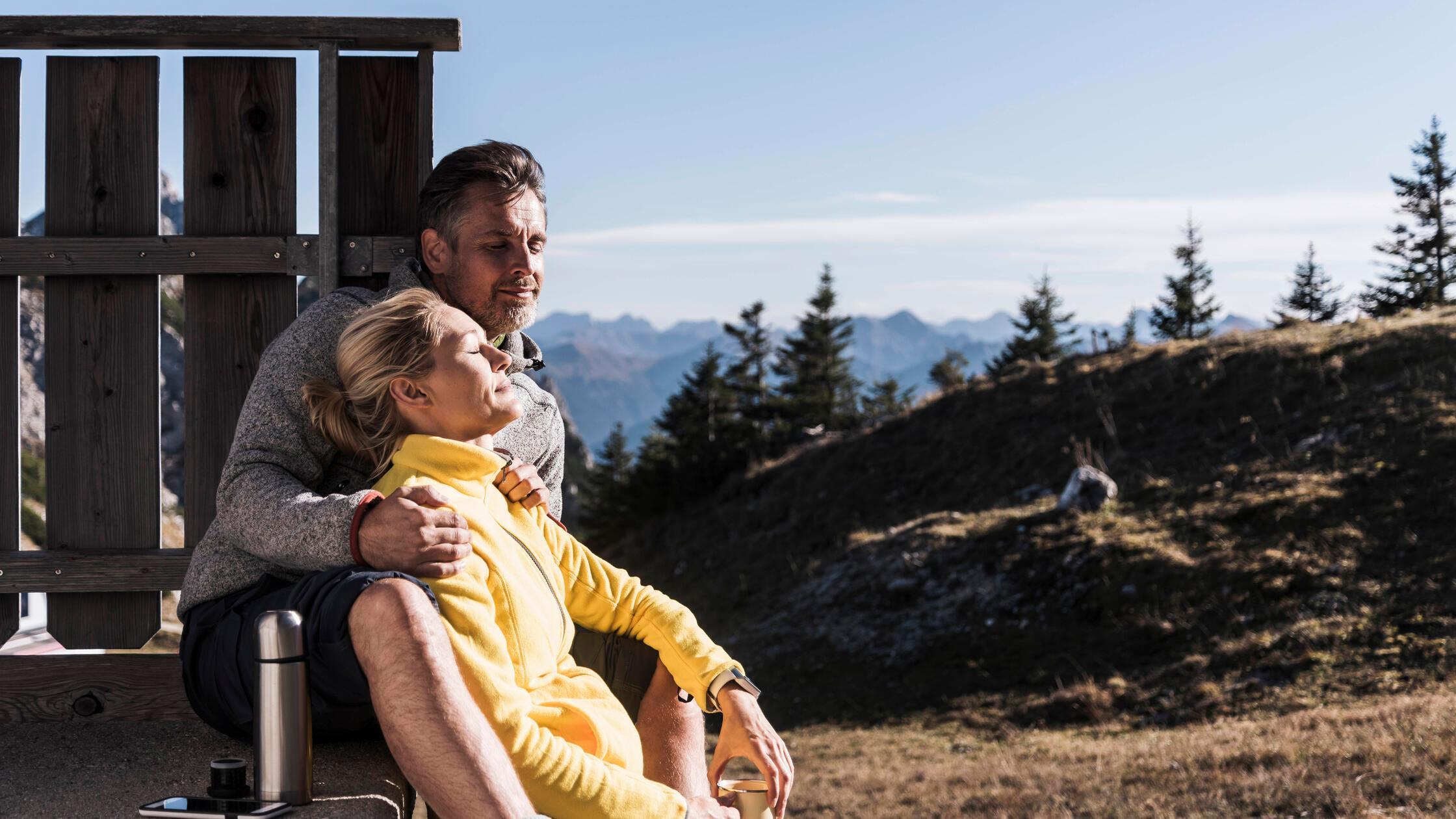 Relaxed woman leaning on boyfriend and sitting nea