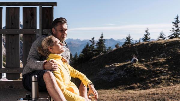 Relaxed woman leaning on boyfriend and sitting nea