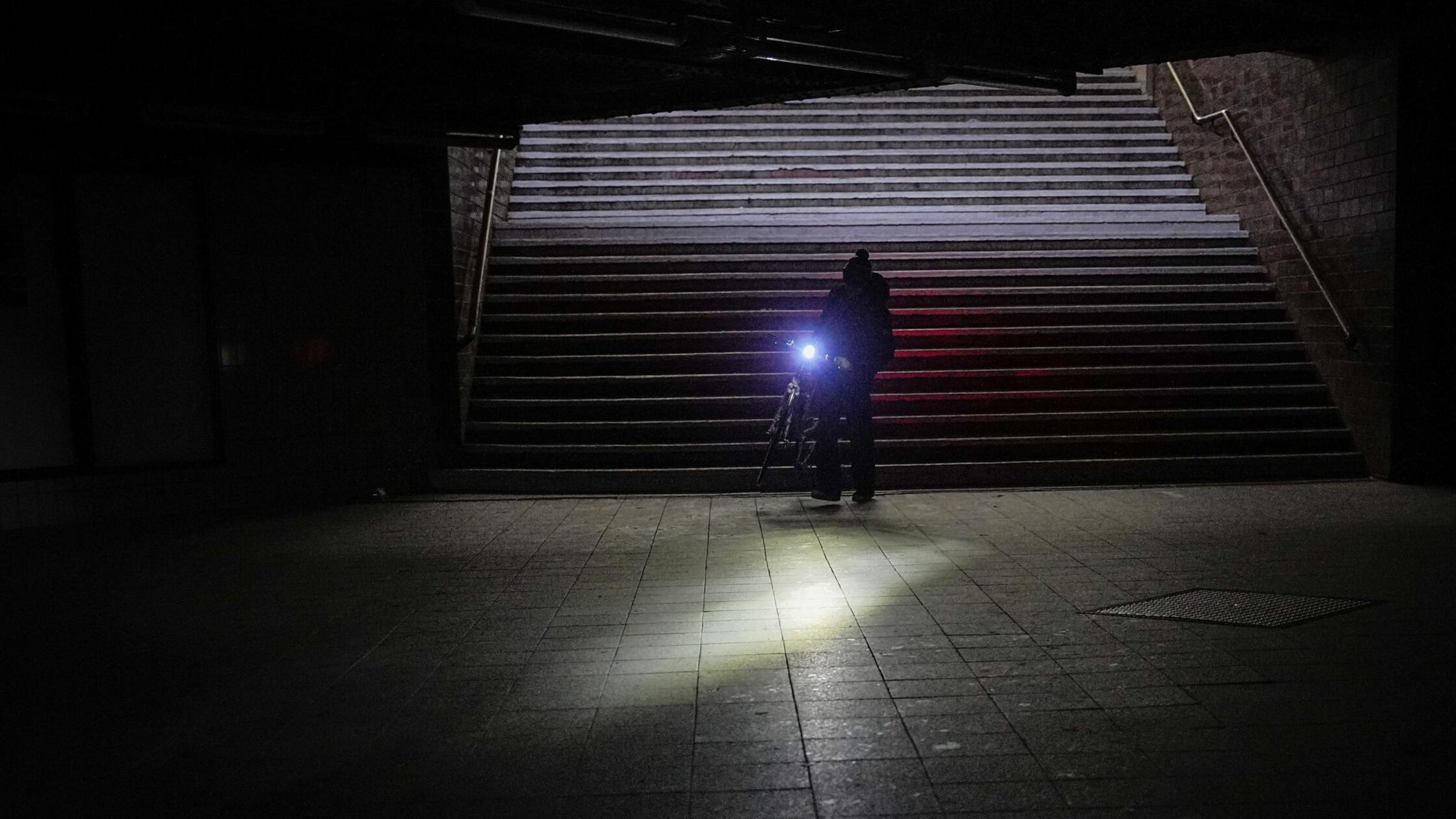 Ein Mann geht nach dem Stromausfall mit seinem Fah