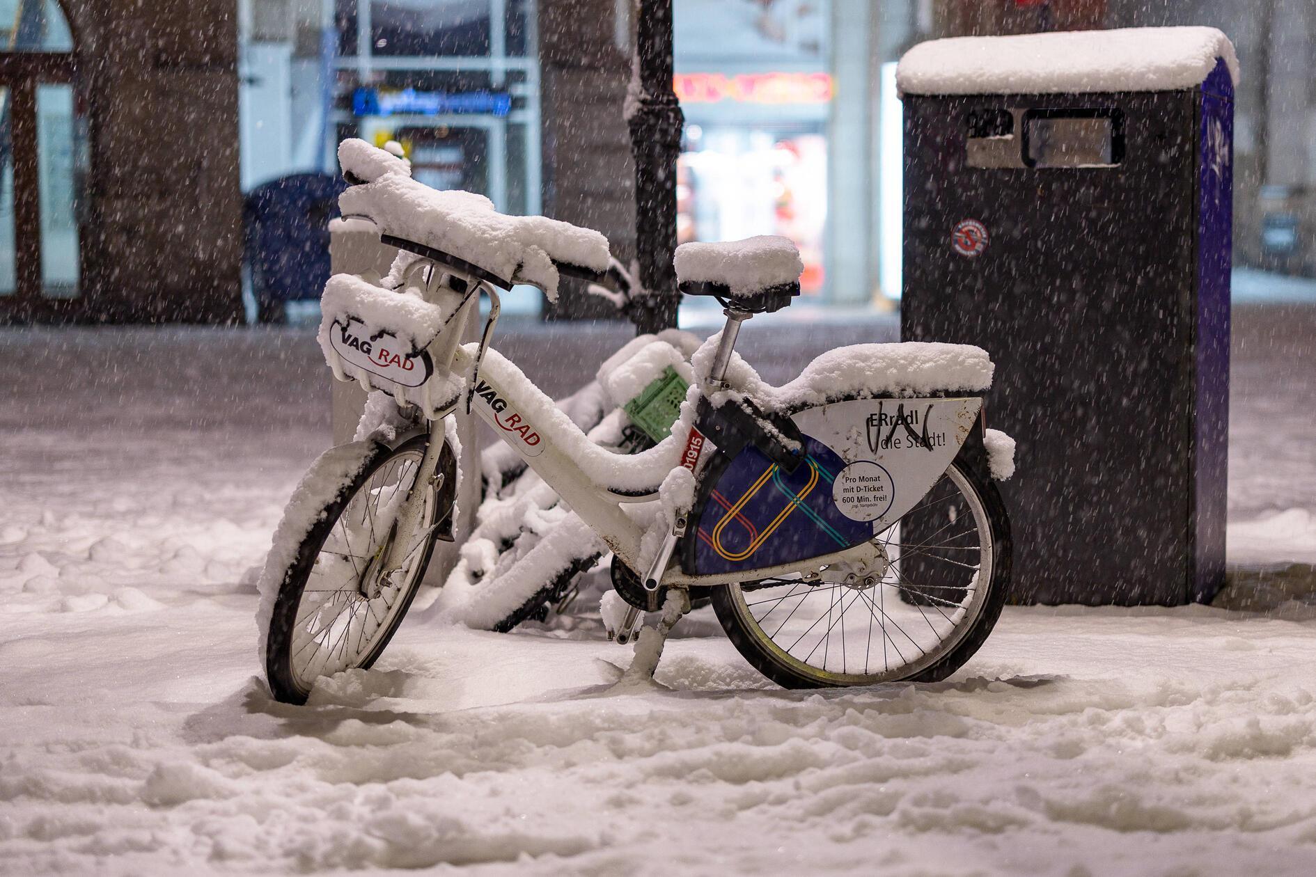 Ein VAG-Leihfahrrad steht bei starkem Schneefall in der Innenstadt von Nürnberg.