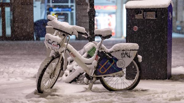 Ein VAG-Leihfahrrad steht bei starkem Schneefall in der Innenstadt von Nürnberg.