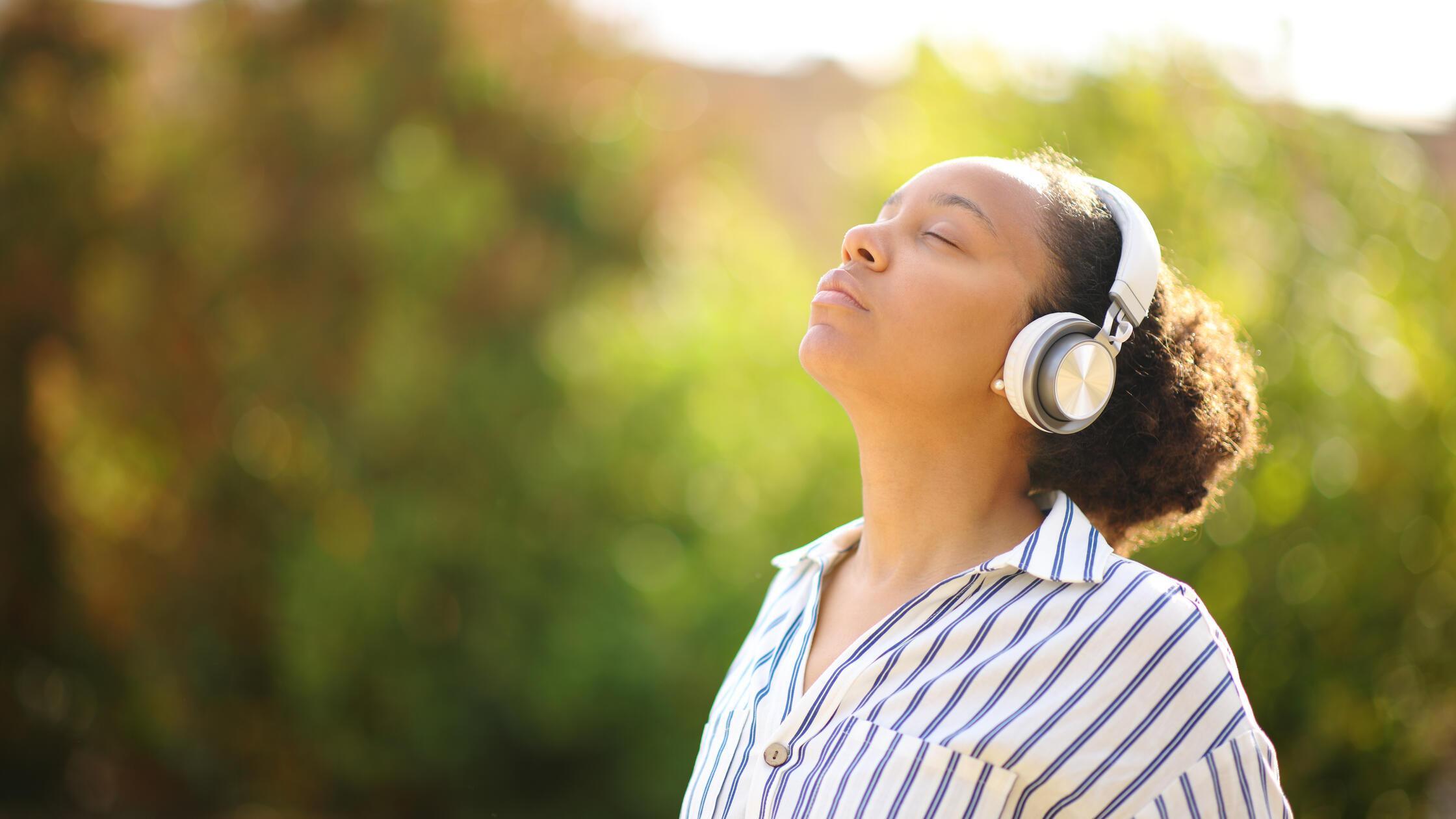 Black woman meditating using headphone, Black woma