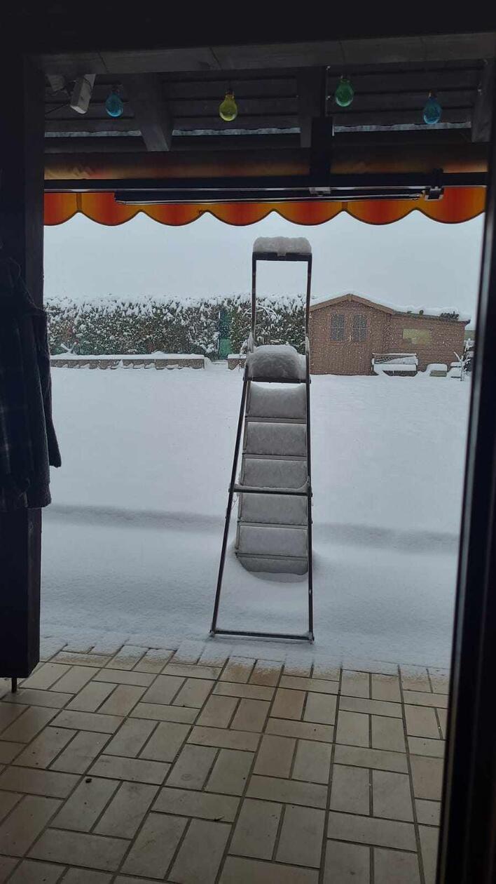Auf den Treppenstufen der stehengelassenen Leiter lässt sich gut erkennen, wie die Schneeschicht immer weiter wächst.