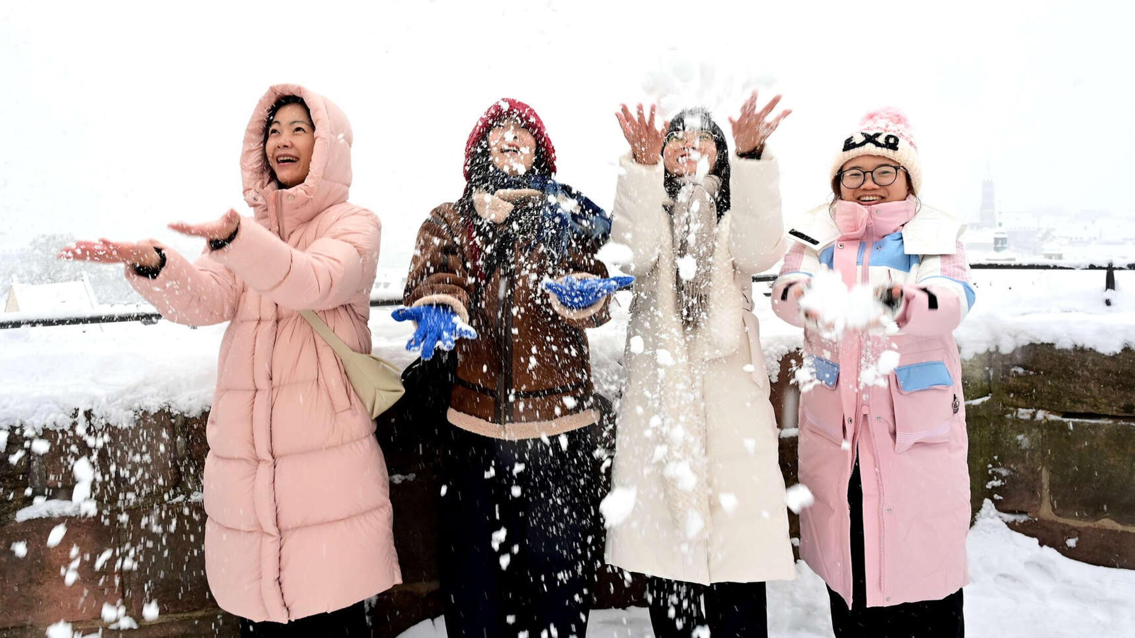 Vier Freundinnen haben sich auf der Burg den besten Ausblick auf die Stadt verschafft. Jetzt soll es Schnee regnen.