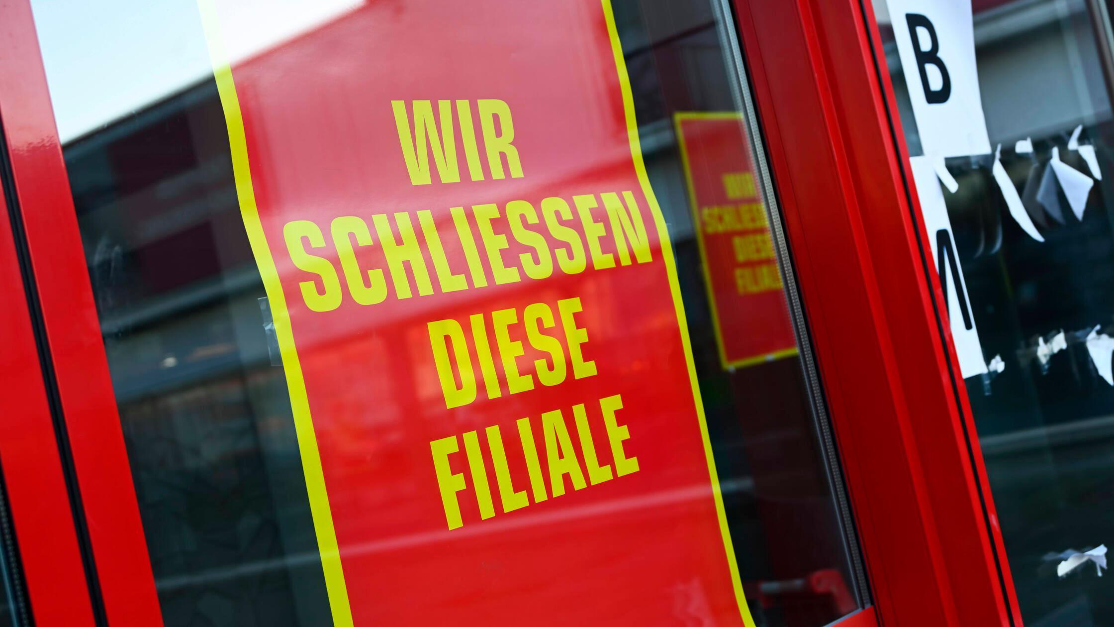 Schild mit Aufschrift Wir schließen diese Filiale 