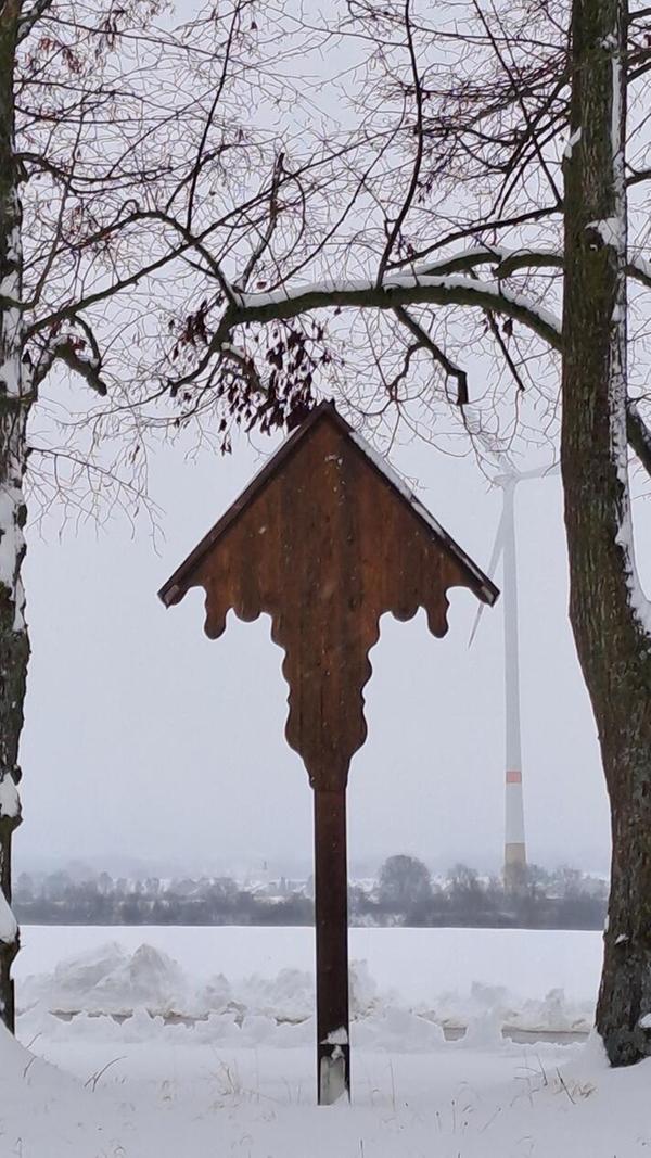 Noch ein Bild von Michael Harrer aus Jahrsdorf. Vorne das Feldkreuz zwischen den zwei Bäumen. Im Hintergrund ist eines der beiden Windräder im Schneetreiben zu sehen.