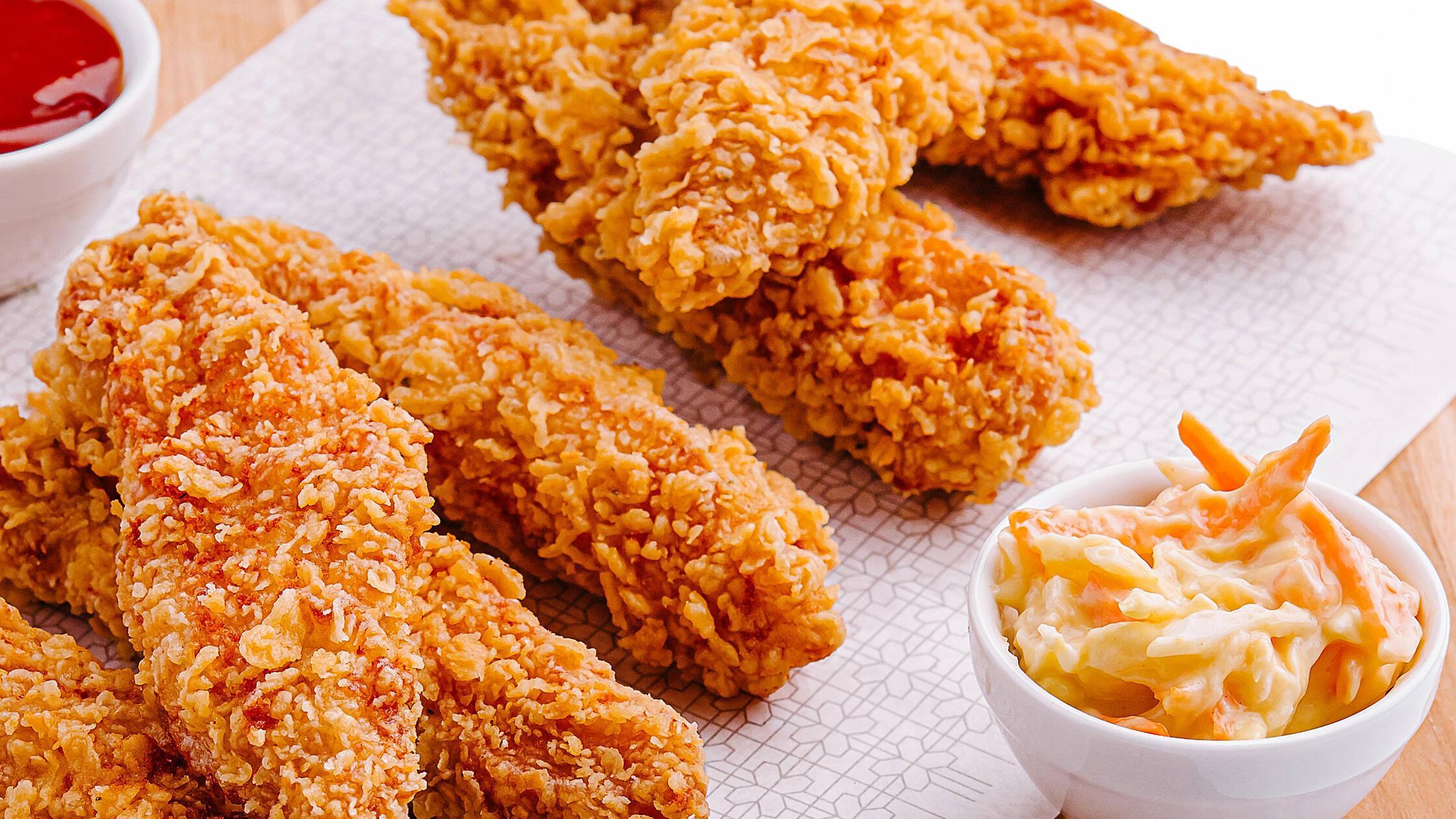 Knusprig gebratene Hähnchenteile, serviert mit Dip