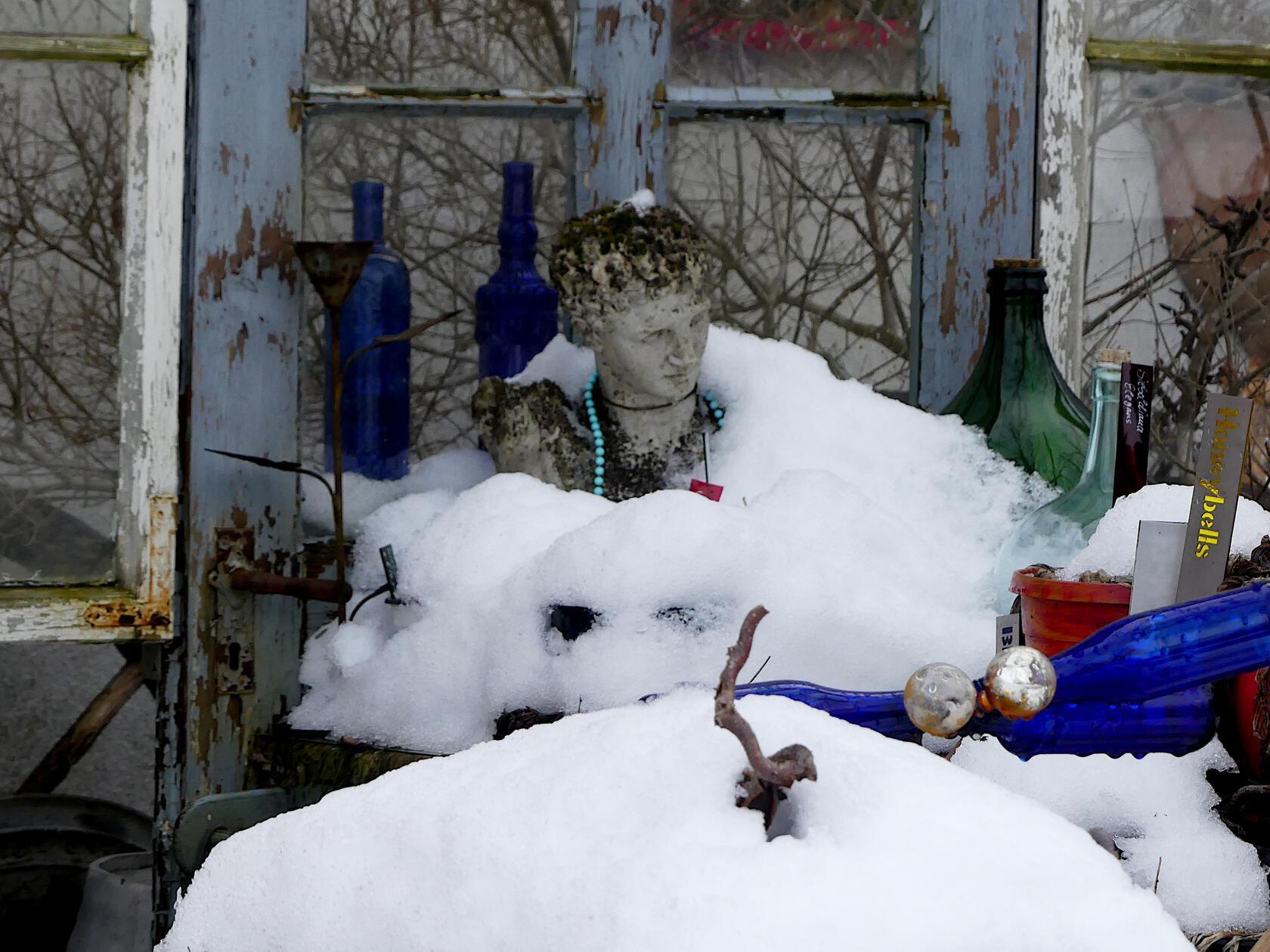 Wie ein weißes Kleid türmt sich der Schnee um diese Büste. Vielleicht ein Hochzeitskleid?