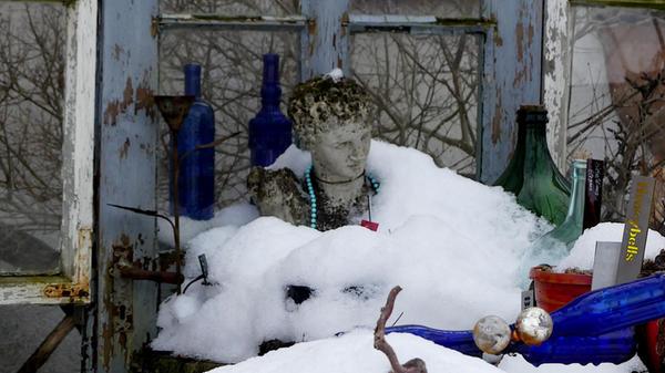 Wie ein weißes Kleid türmt sich der Schnee um diese Büste. Vielleicht ein Hochzeitskleid?