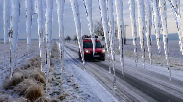 Lange Eiszapfen hängen von einem Verkehrsschild an