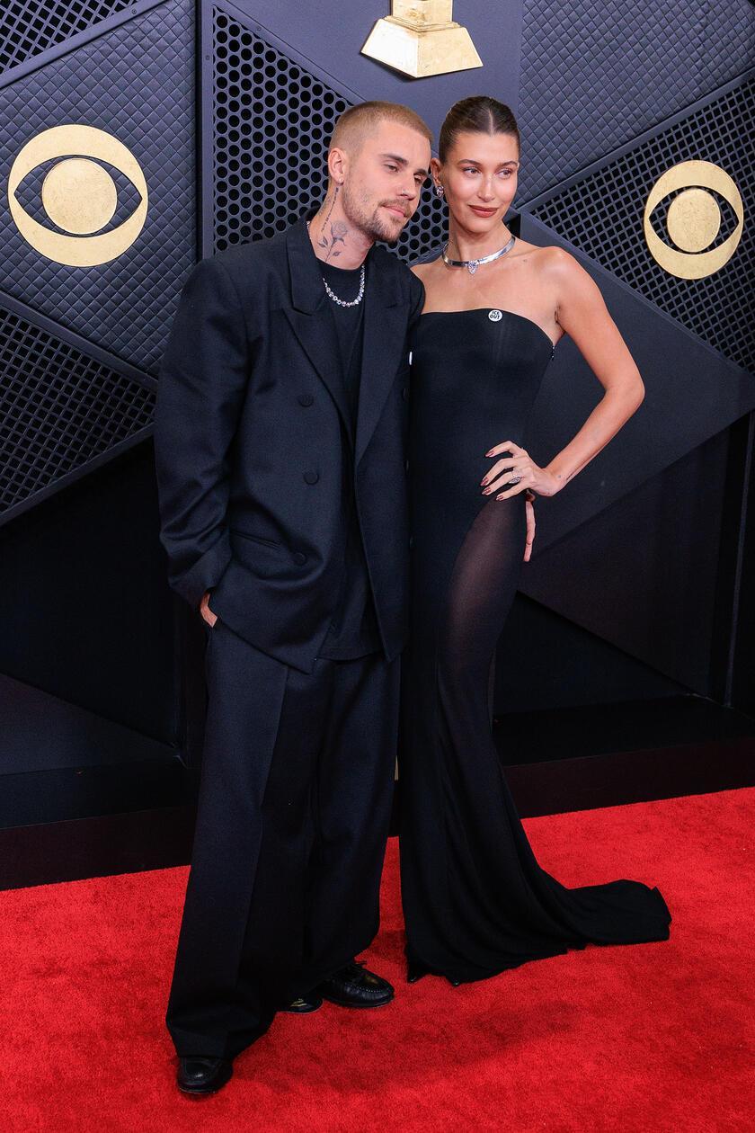Hailey Bieber, hier mit ihrem Mann Justin auf dem roten Teppich, setzte, wie viele andere Künstler und Künstlerinnen auch an diesem Abend, ein politisches Statement. Auf ihrem schwarzen Kleid strahlt ein Anstecker in weiß. Darauf zu lesen sind die Worte "Ice out" - eine klare Botschaft an die Abschiebe-Behörde von US-Präsident Donald Trump.