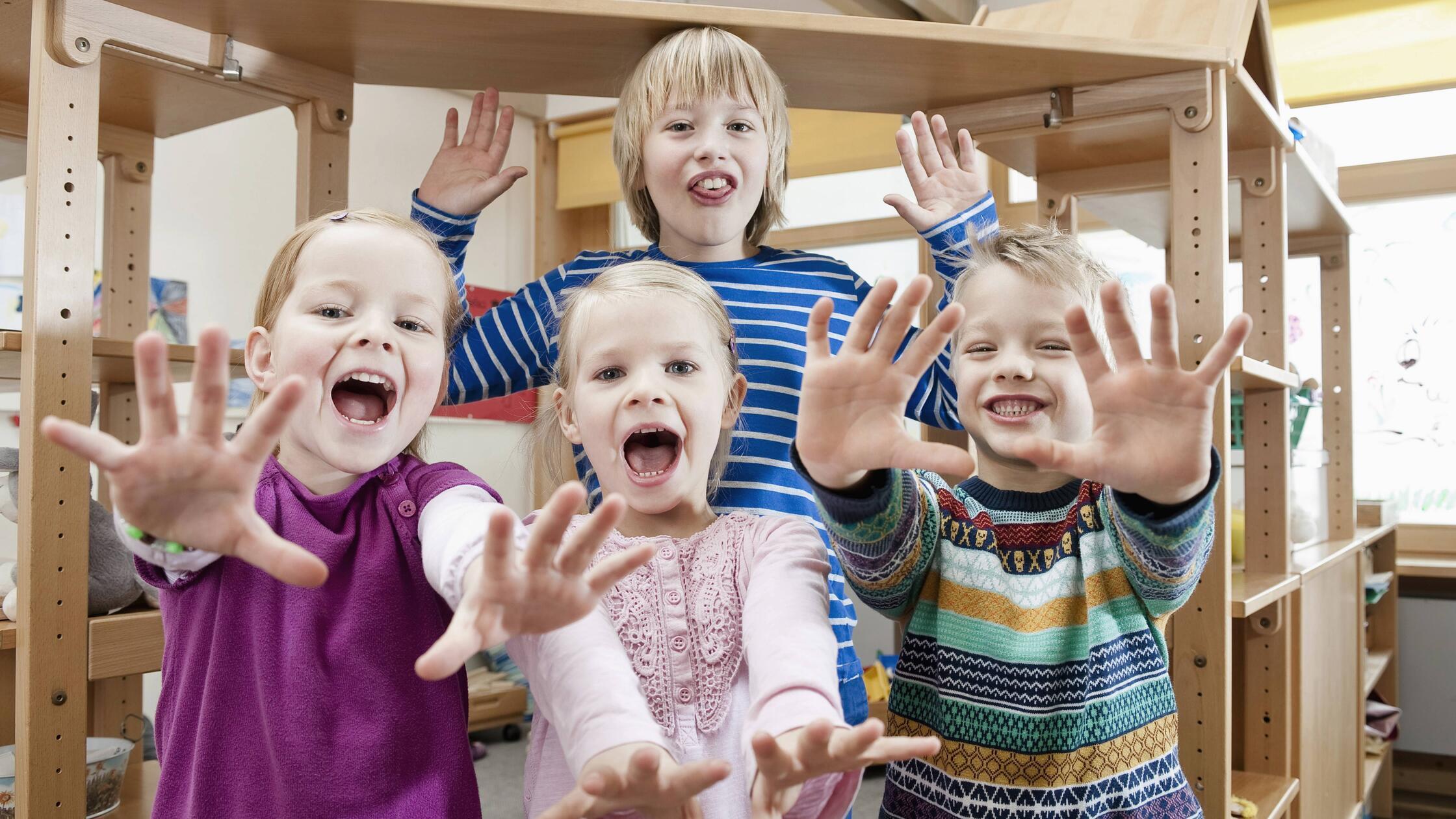 Four children with outstretched arms screaming mit
