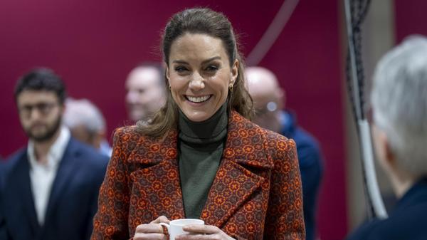 Prinzessin Kate von Wales steht mit einer Tasse be