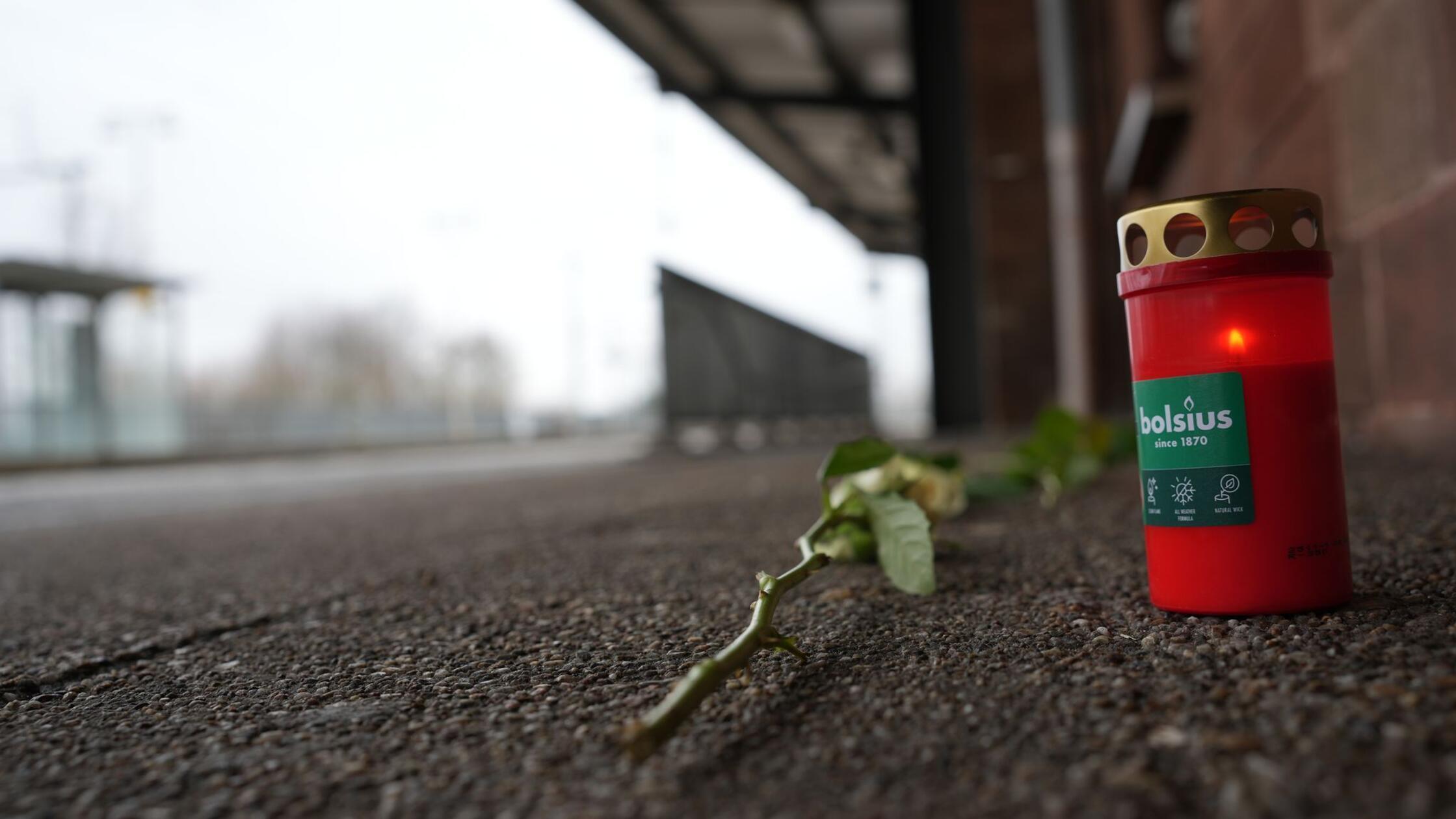 Blumen und Kerzen liegen am Bahnsteig in Landstuhl