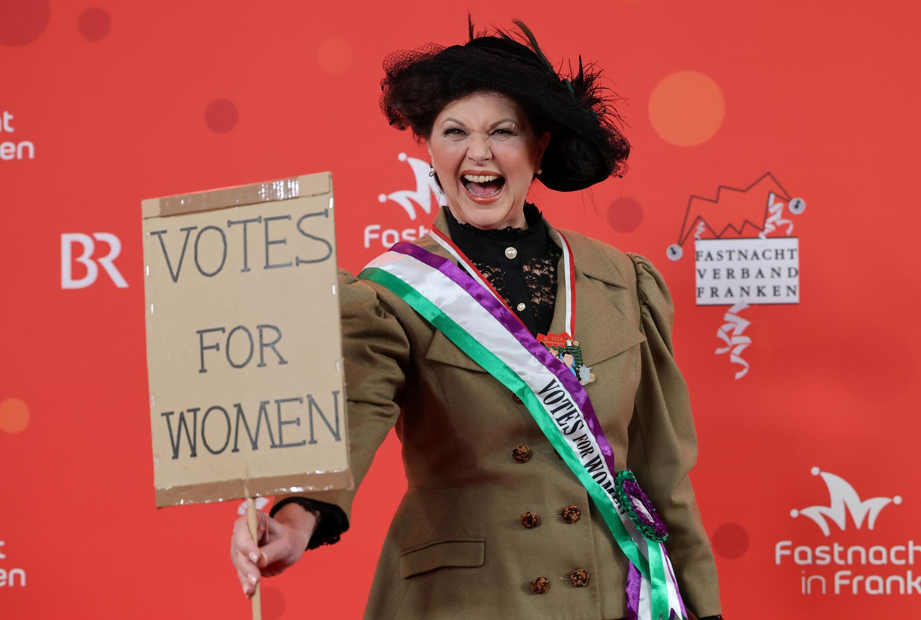 Ilse Aigner (CSU), Präsidentin des Bayerischen Landtags, lässt sich das Spektakel in Veitshöchheim ebenfalls nicht nehmen. "Votes for Women" steht auf einem Karton, den sie in die Kamera hält.