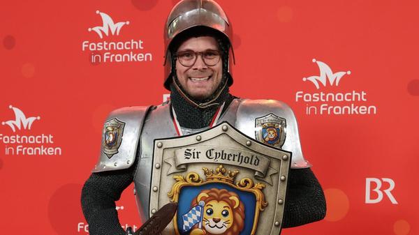 Fabian Mehring (Freie Wähler), Bayerischer Staatsminister für Digitales, kommt als Ritter. Auf seinem Schild zu sehen: Der bayerische Löwe, der zuletzt ein Emoji werden sollte.