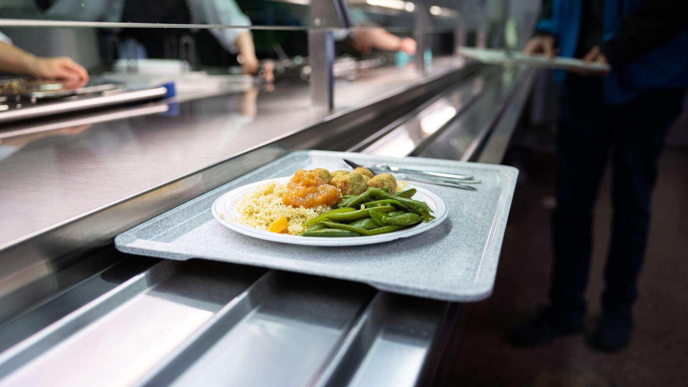 Ein Tablett mit Essen liegt bei einer Essensausgab